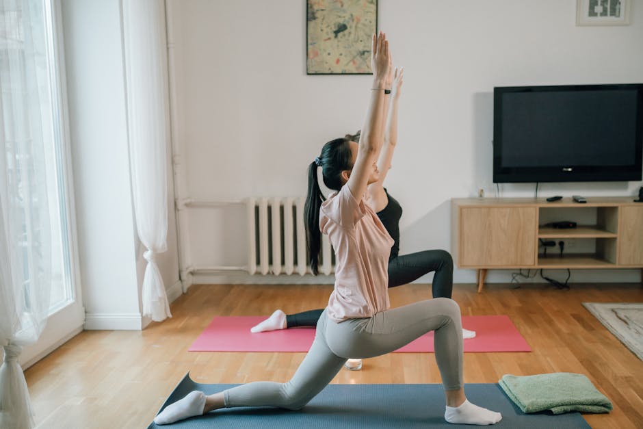Two women practicing yoga indoors on mats, focusing on fitness and mindfulness in a cozy home setting.