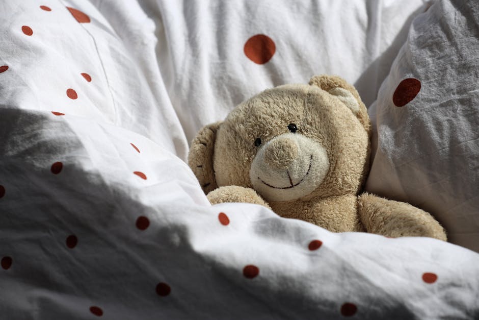 Cute teddy bear nestled in polka dot bedding, creating a cozy and inviting atmosphere.